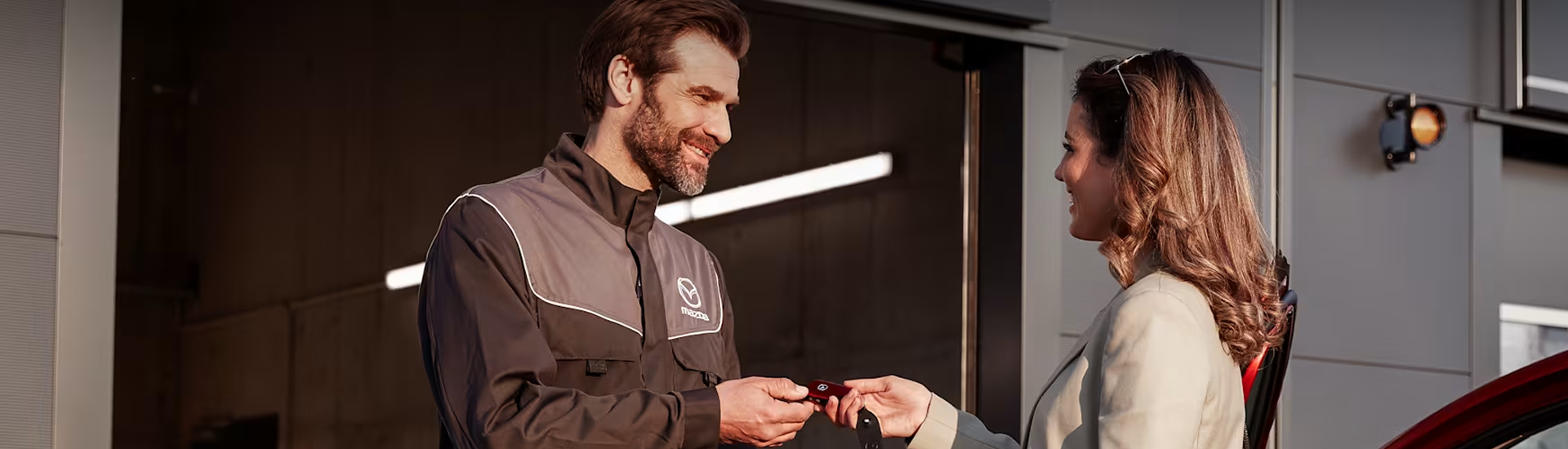 Mazda important actions - woman handing man a key